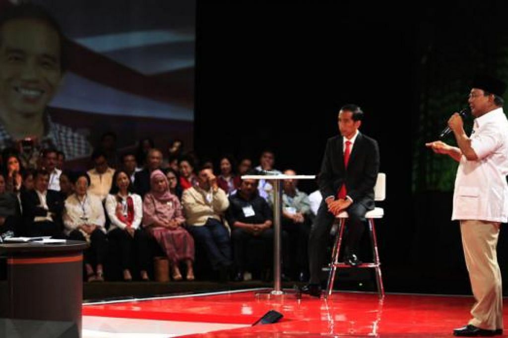 BERDEBAT: Encik Prabowo Subianto (kanan) mengetengahkan hujahnya sedang pencabarnya, Encik Joko Widodo (dua dari kanan), mendengar samasa perdebatan kedua antara calon Presiden, yang disiarkan di televisyen kelmarin. – Foto REUTERS