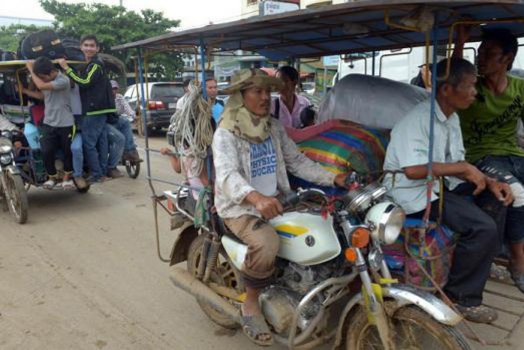 KEMBALI KE TANAH AIR: Para pekerja asal Kemboja menggunakan kenderaan buatan sendiri untuk kembali ke kampung mereka selepas melepasi sempadan Thailand di Poipet di wilayah Banteay Meanchey kelmarin. - Foto AFP