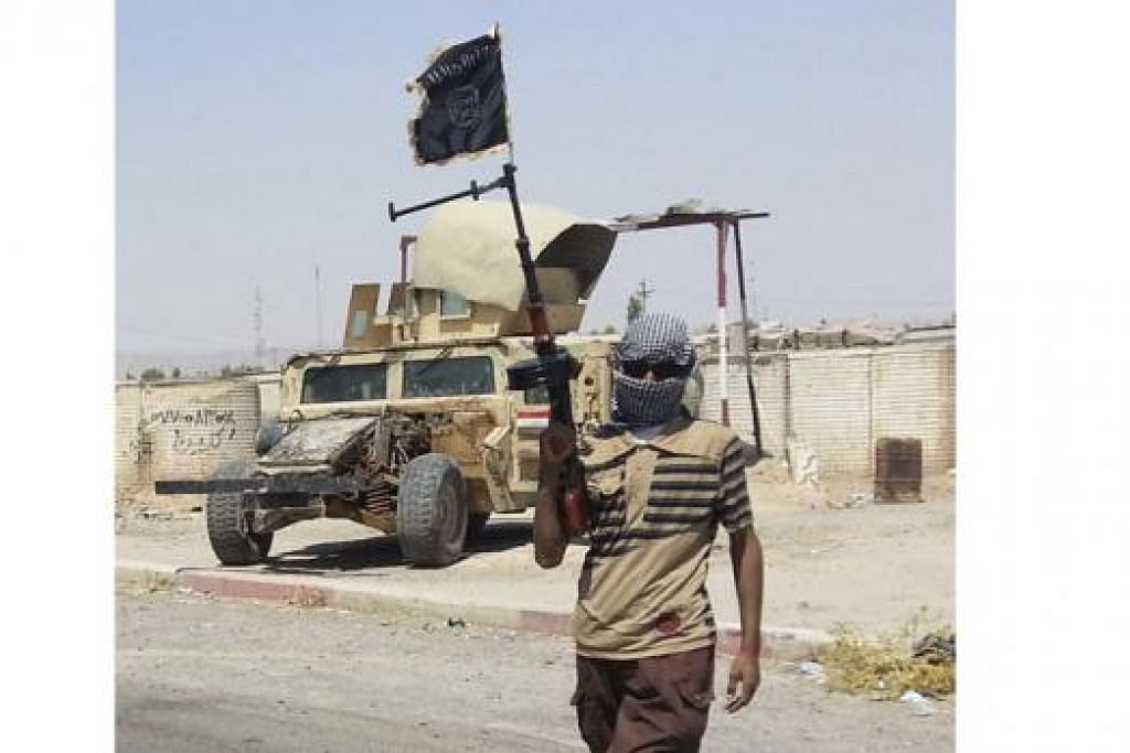 PUSAT PEMERIKSAAN: Seorang pejuang ISIL berdiri di pusat pemeriksaan di bandar Baiji, utara Baghdad.