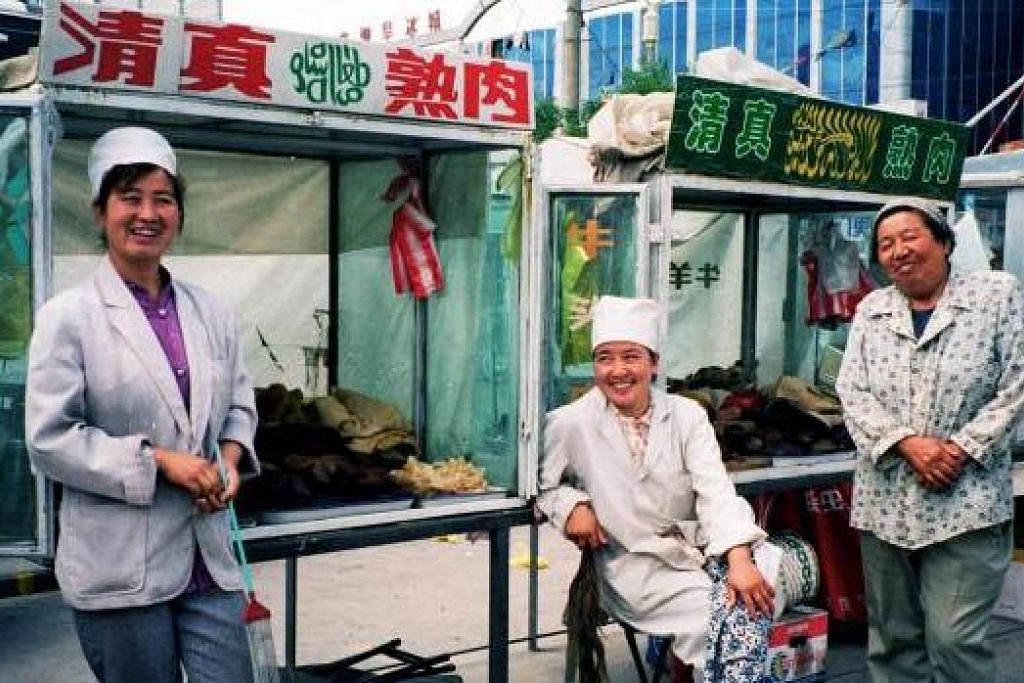 MAKANAN ISLAM CARA CINA: Tiga wanita penjual makanan Islam ini berjaja makanan halal di salah satu jalan di Hohhot, bandar utama di Inner Mongolia. – IHSAN PEMBACA