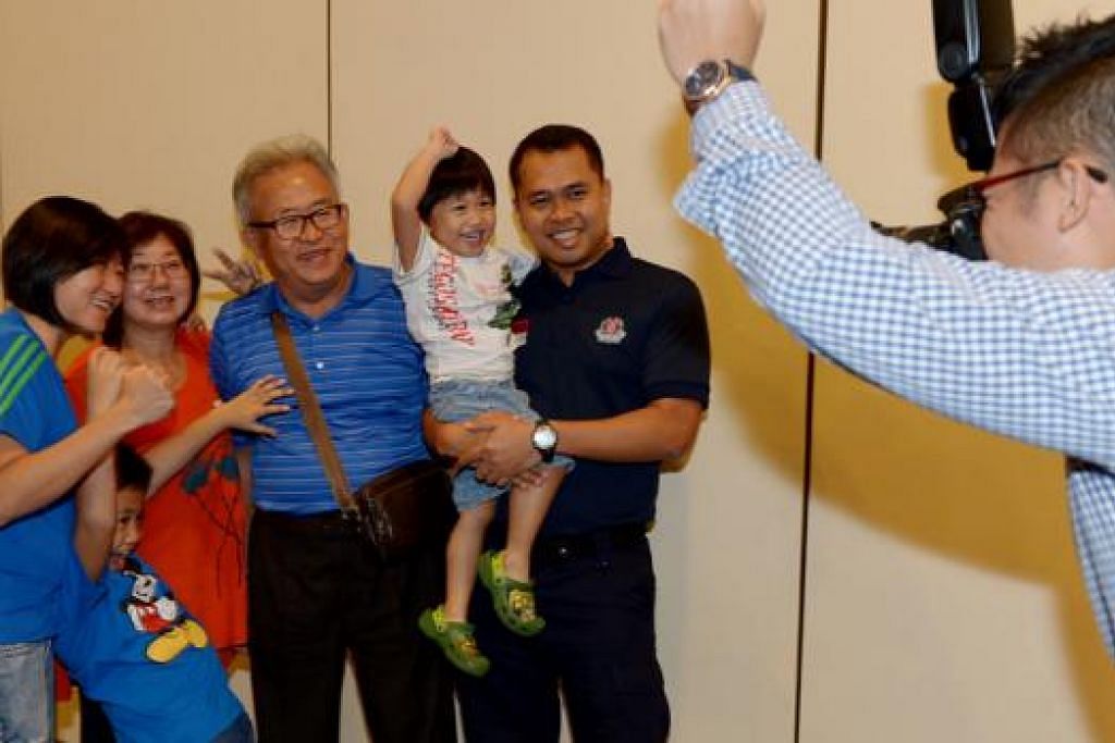 KEMBALI KE PANGKUAN KELUARGA : Kepulangan Inspektor Mohd Yazid (mendukung anaknya) ke Singapura selepas dua minggu di Surabaya, disambut dengan penuh gembira oleh keluarga termasuk isterinya, (paling kiri) Cik Qistina Chai dan dua anak lelaki mereka. - Foto TUKIMAN WARJI