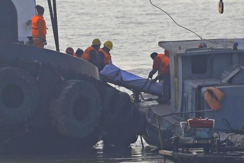 MAUT SEMASA CARI REZEKI: Pekerja penyelamat mengalihkan antara mayat yang ditemui kelmarin setelah bot tunda di mana empat warga Singapura sedang bertugas di dalamnya karam di Sungai Yangtze, berdekatan wilayah Jiangsu. - Foto REUTERS