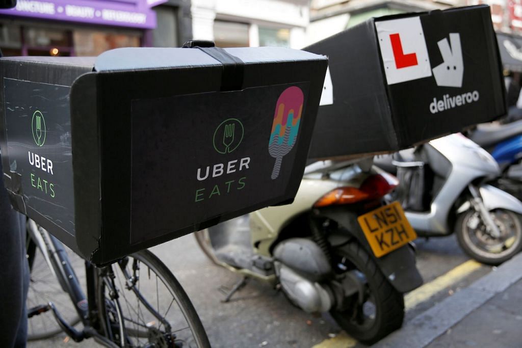 Sebuah basikal penghantaran makanan UberEATS diletak disebelah skuter Deliveroo di London. Encik Tharman berkata pekerjaan ekonomi gig tidak memberi pekerja faedah pekerjaan yang dinikmati pekerja pekerjaan biasa, seperti faedah jegaan keesihatan. 