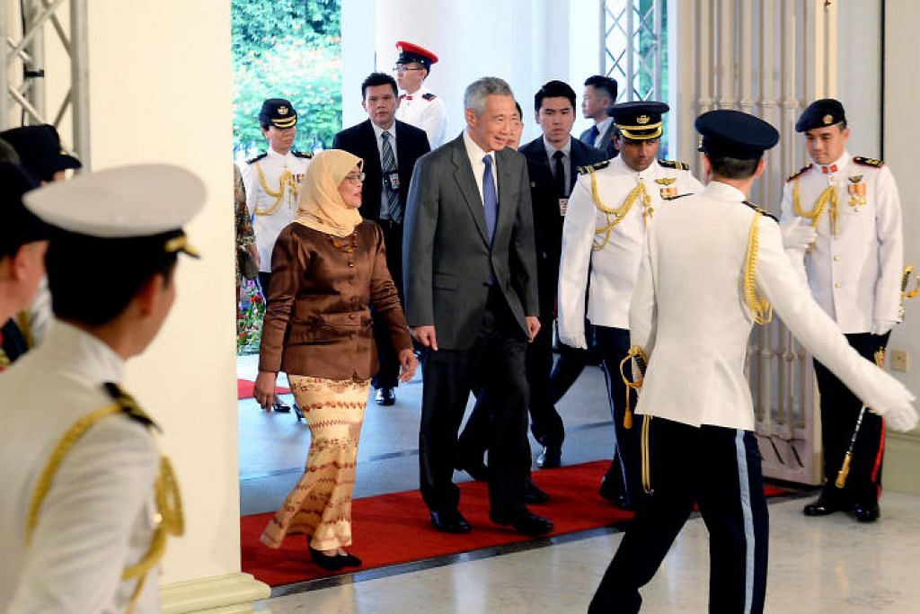 DUA PEMIMPIN PENTING: Perdana Menteri Lee Hsien Loong mengiringi Puan Halimah semasa melangkah masuk ke Istana.