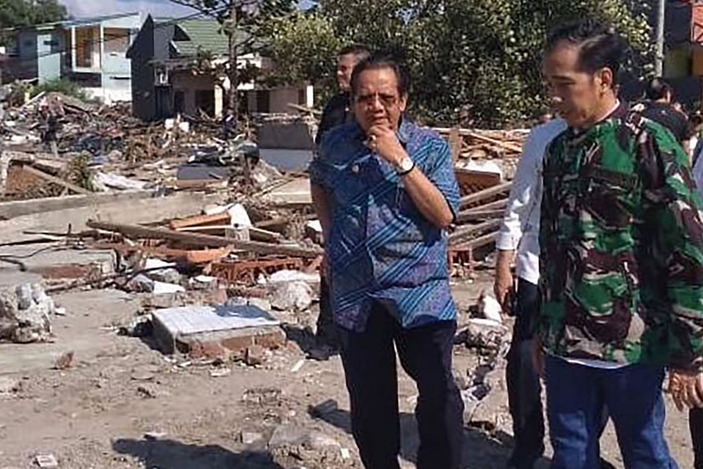 KUNJUNGI LOKASI BENCANA: Encik Jokowi (kanan), yang mengunjungi daerah Balaroa di Palu semalam, meminta penduduk agar bersabar sementara menunggu bantuan tiba. - Foto AFP