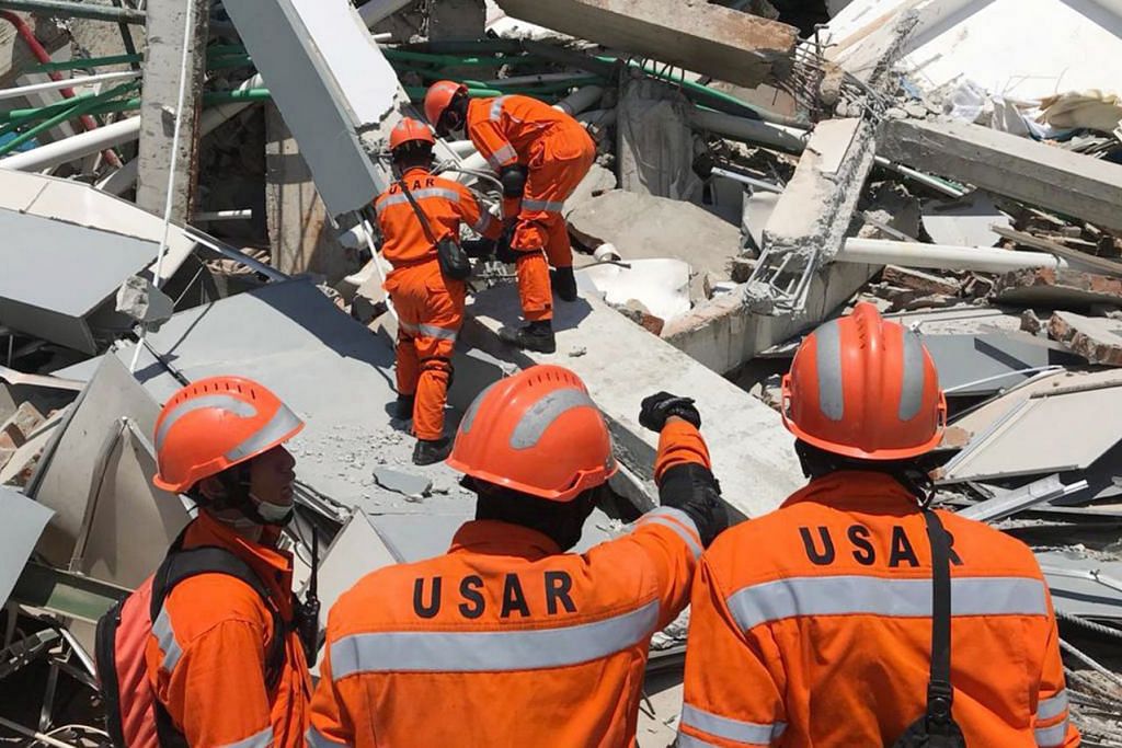USAHA MENCARI: Pasukan penyelamat berusaha mencari mangsa yang terperangkap dalam runtuhan Hotel Roa Roa di Palu, Sulawesi Tengah. - Foto EPA