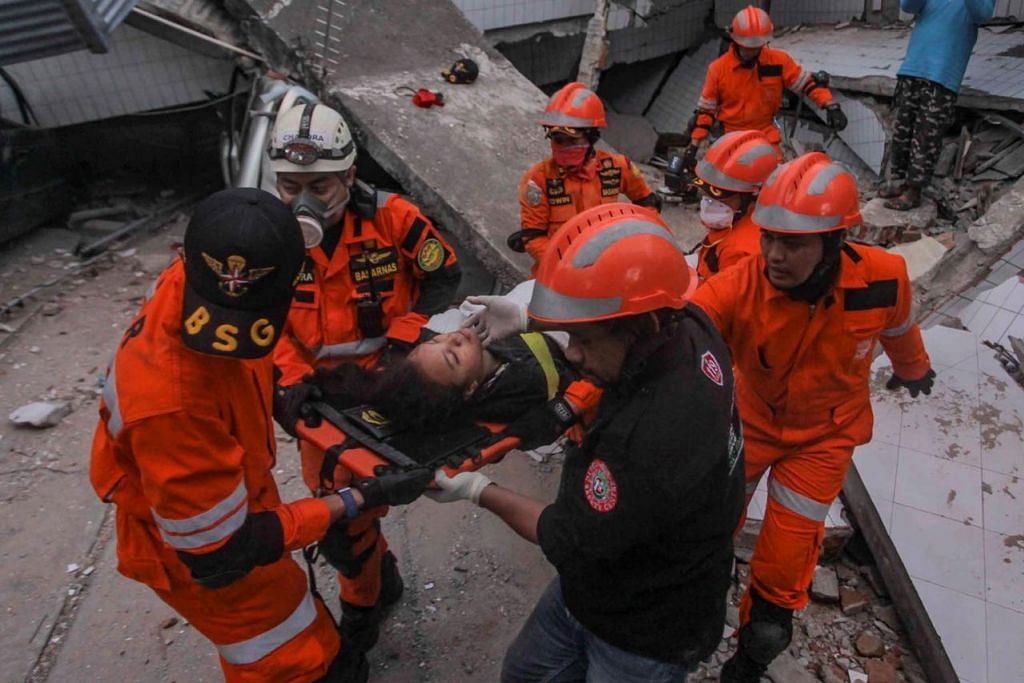 BANTU MANGSA: Pasukan penyelamat memindahkan seorang mangsa yang berjaya dikeluarkan daripada sebuah restoran yang roboh akibat gempa di Palu, Sulawesi Tengah. - Foto REUTERS