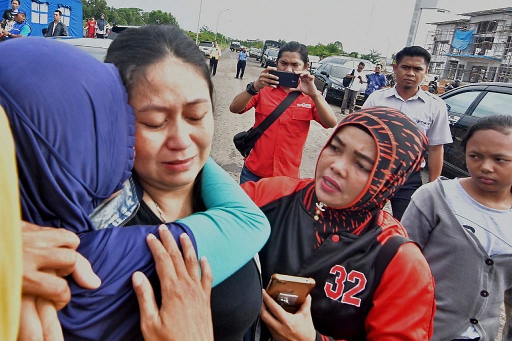 TANGISAN KELUARGA: Anggota keluarga penumpang tidak dapat menahan kesedihan dan mereka turut ke pusat maklumat bagi mendapatkan data dan informasi kejadian pesawat terhempas itu dari pihak berkuasa. - Foto AFP 