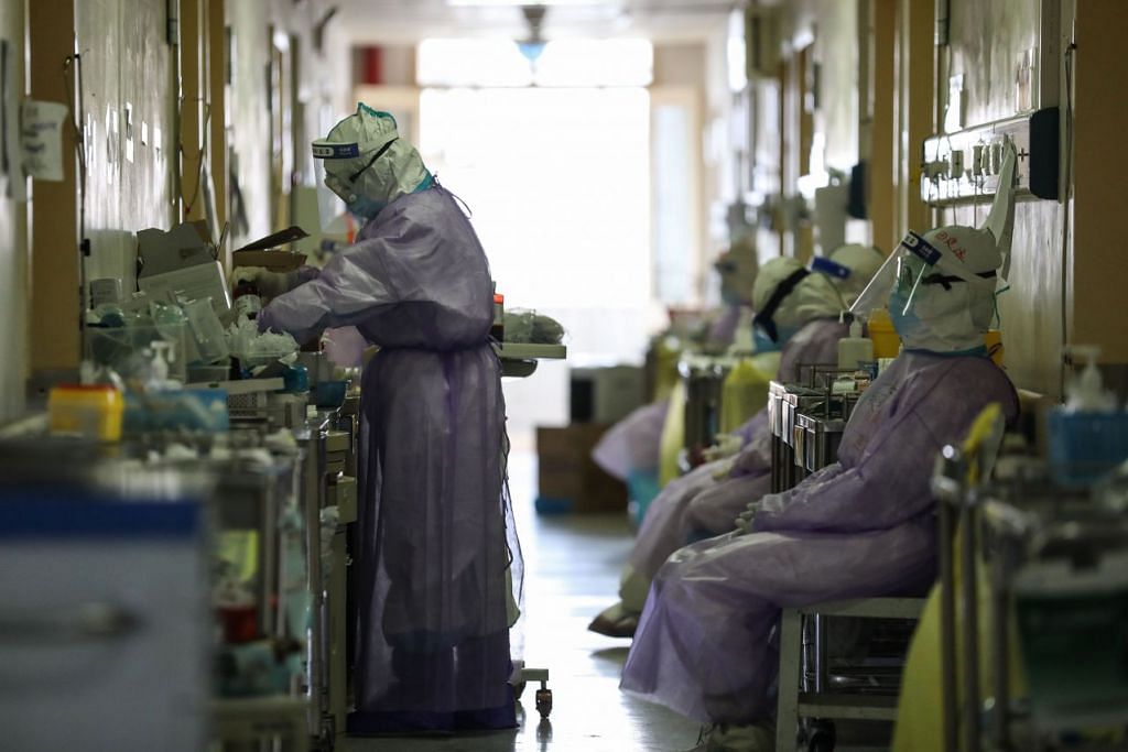 Beberapa pekerja kesihatan sedang bertugas di Hospital Palang Merah di Wuhan, wilayah Hubei, China pada 28 Februari 2020. - Foto: AFP.