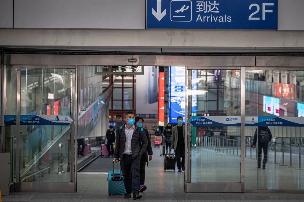 Beberapa penumpang pesawat dilihat memakai pelitup setibanya di Lapangan Terbang Antarabangsa Ibu Kota Beijing, China pada 2 Mac 2020. Foto: EPA-EFE