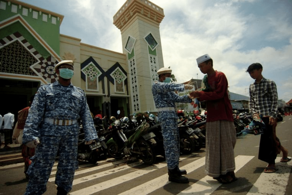 Pekerja memberikan jemaah solat Jumaat sanitiser tangan di sebuah masjid di Tegal, wilayah Jawa Tengah, Indonesia. - Foto REUTERS