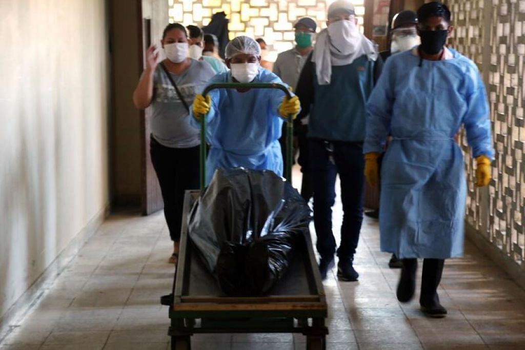 DETIK HIBA: Seorang petugas bilik mayat mengusung mayat mangsa Covid-19 di hospital serantau di Iquitos, bandar terbesar di Peruvian Amazon, Peru. Gambar dirakamkan pada 14 Mei lalu di tengah-tengah penularan koronavirus yang memuncak.