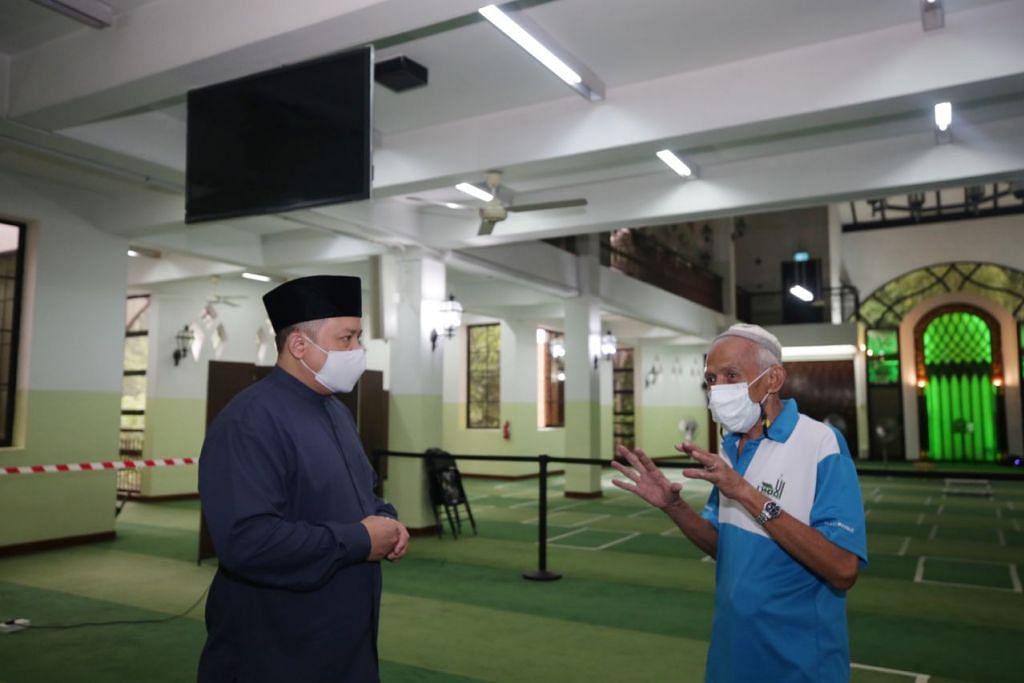 Pengerusi Masjid Al-Amin, Haji Muhammad Khairul Jameel Yahya (bersongkok), berbincang bersama kakitangan masjid. – Foto BH oleh TIMOTHY DAVID