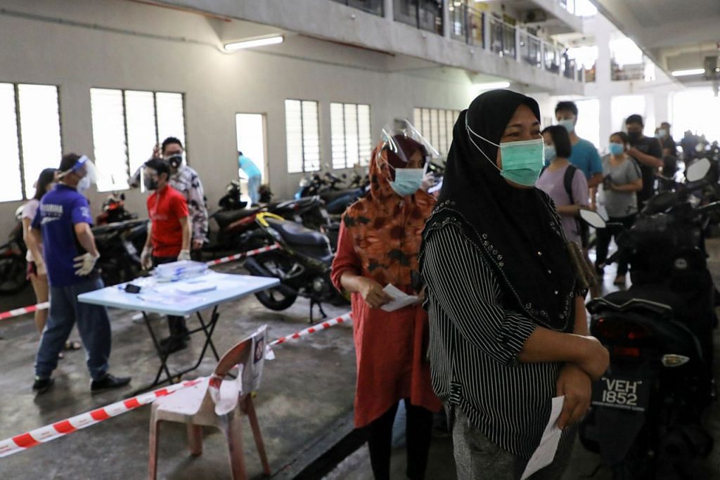 SERTAI PROGRAM VAKSINASI: Beberapa warga Malaysia beratur mahu mendapatkan suntikan vaksin Covid-19. Walaupun negara itu mencatat kadar rekod jangkitan harian, kian ramai warganya tampil mendapatkan suntikan dengan kadar vaksinasi di Malaysia, selain Singapura, antara yang tertinggi di Asia Tenggara. - Foto REUTERS