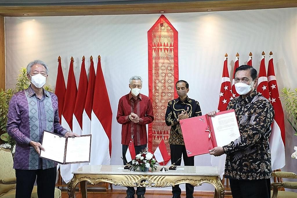 METERAI PERJANJIAN: Encik Teo Chee Hean (depan, kiri) dan Menteri Penyelaras Ehwal Maritim dan Pelaburan Indonesia, Encik Luhut Pandjaitan (kanan), menandatangani perjanjian di Rahat Pemimpin bulan lalu. Turut hadir di pertemuan itu ialah (belakang d