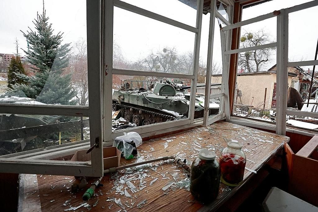 TERUS DIBEDIL: Sebuah kereta kebal yang musnah dilihat melalui tingkap rumah yang turut musnah di bandar Bucha dekat ibu kota Ukraine, Kyiv, yang menjadi sasaran serangan tentera Russia sedang peperangan kededua negara itu memasuki hari ketujuh semal