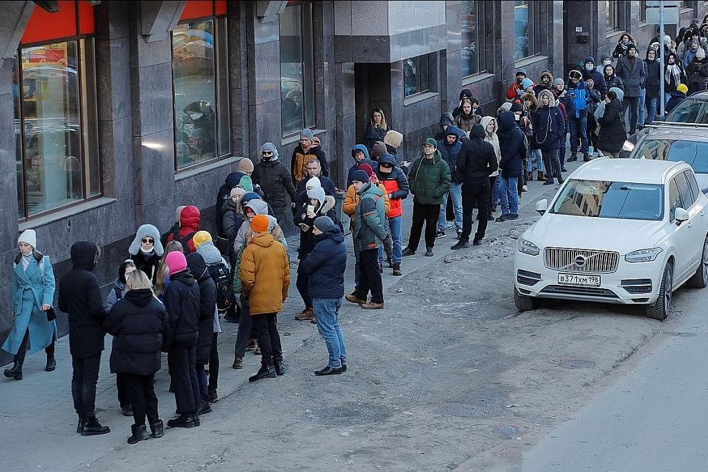 KESAN SEKATAN TERHADAP RUSSIA: Rakyat Russia beratur panjang menunggu giliran untuk mengeluarkan wang tunai dari ATM di Saint Petersburg Ahad lalu. Selepas menunggu berjam-jam, ada mendapati ATM ketiadaan wang. - Foto REUTERS