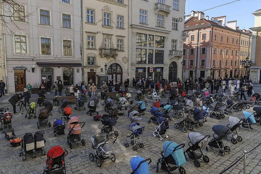 INGATAN PADA SI COMEL: Lebih 100 kereta sorong bayi disusun semasa satu persembahan yang dinamakan "Harga Peperangan" di pusat bandar Lviv, Ukraine, kelmarin. Ia sebagai memperingati lebih 100 kanak-kanak yang terbunuh akibat serangan Russia ke atas 