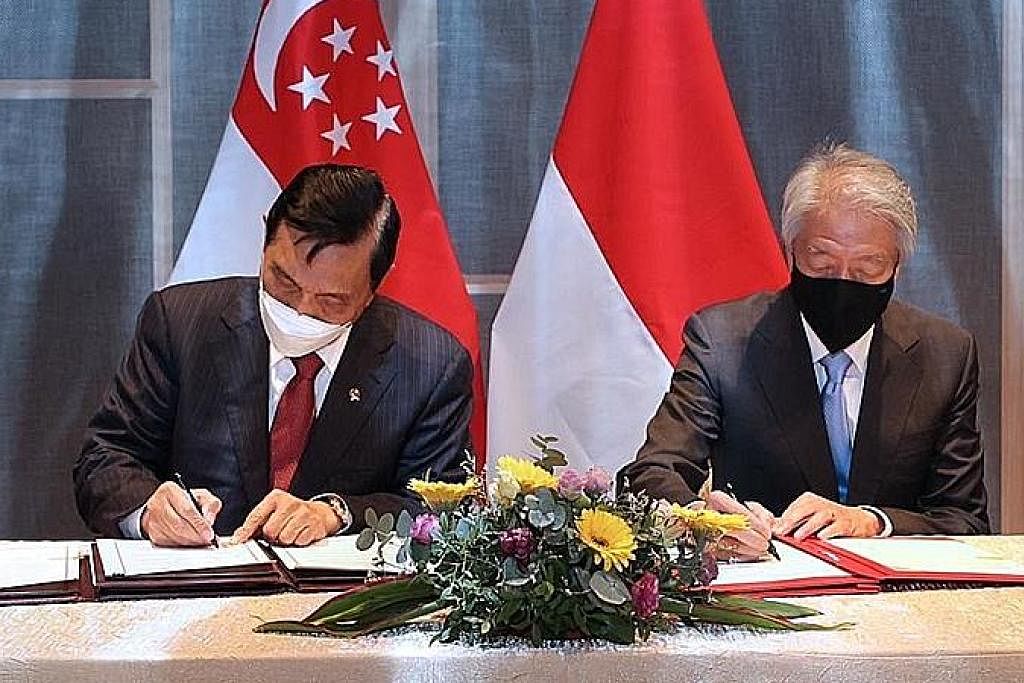 TINGKAT KERJASAMA: Encik Teo Chee Hean (paling kanan) dan Encik Luhut Pandjaitan menandatangani MOU yang akan melihat kerjasama lebih mendalam antara Singapura dengan Indonesia berhubung kemampanan dan perubahan iklim. - Foto MCI