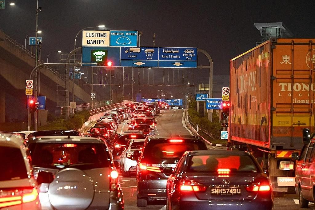 SESAK TRAFIK: Deretan kenderaan mula bersesak-sesak di Pusat Pemeriksaan Woodlands setelah sempadan darat Singapura dan Malaysia dibuka semula pada 12 tengah malam semalam. - Foto AFP