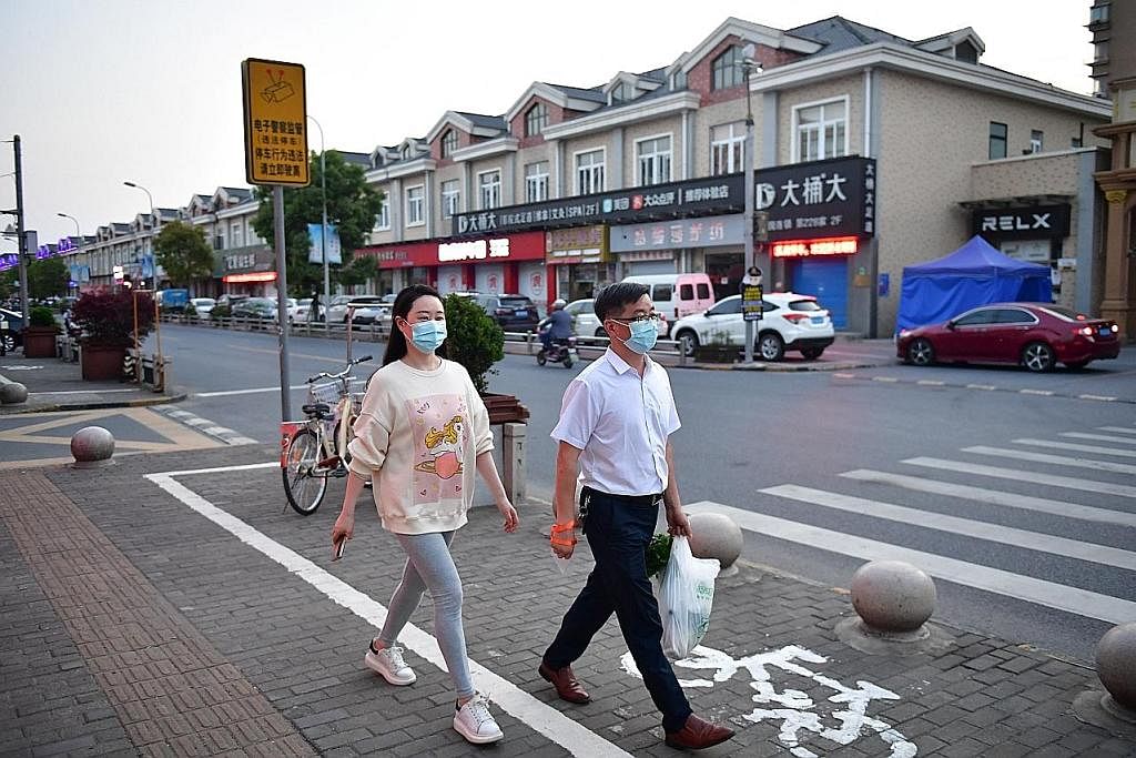 DAPAT AMBIL UDARA: Penduduk Shanghai berjalan di satu kawasan di daerah Jinshan, sedang bandar itu melonggarkan sekatan pergerakan ke atas beberapa kawasan. - Foto REUTERS