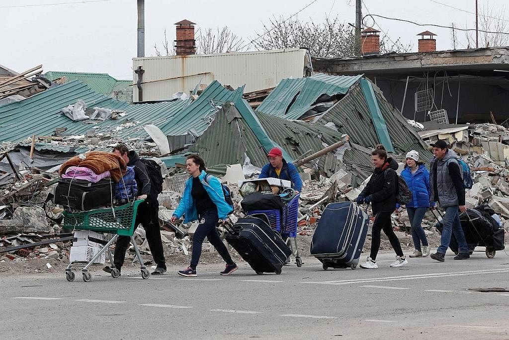 LARIKAN DIRI: Penduduk di Mariupol bergegas meninggalkan kediaman mereka setelah bandar pelabuhan timur Ukraine itu teruk diserang tentera Russia. - Foto REUTERS