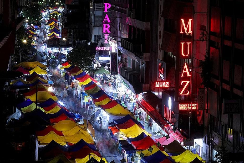 PENIAGA BAZAR TURUT TERJEJAS: Dek pengumuman Raya mengejut, peniaga bazar Raya di Malaysia rata-rata terpaksa melelong barangan mereka sehari lebih awal yang dijadualkan. - Foto REUTERS