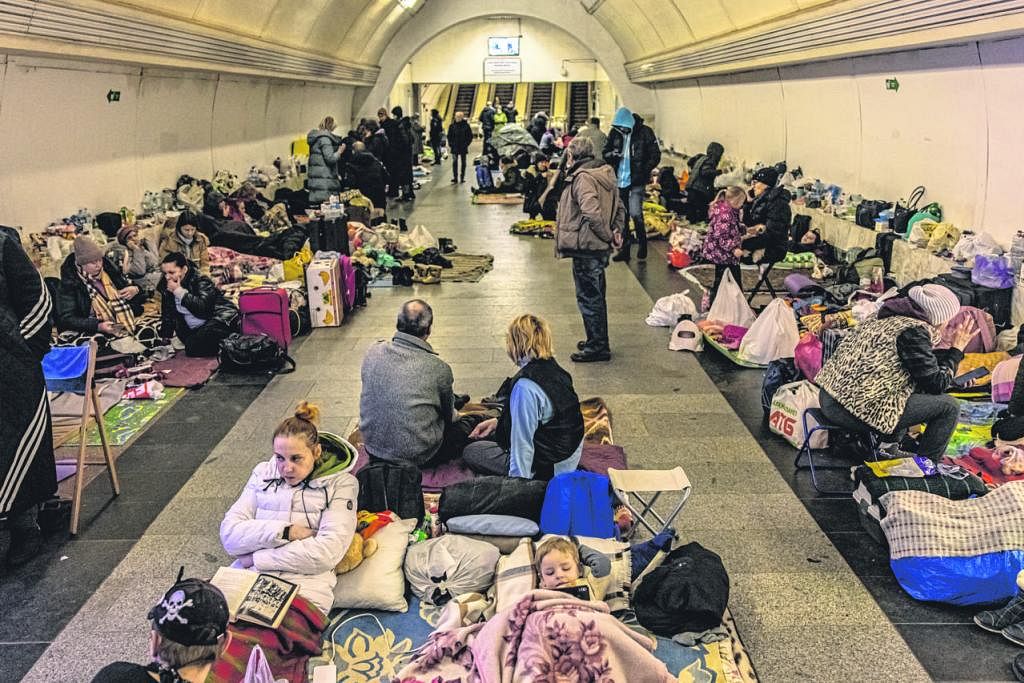 CARI PERLINDUNGAN: Penduduk Ukraine berlindung di stesen kereta api bawah tanah di Kyiv sedang tentera Russia mendekati dan membedil beberapa kawasan berdekatan ibu kota itu. - Foto EPA-EFE TEMPAT KEDIAMAN MUSNAH: Seorang penduduk di kawasan luar ban
