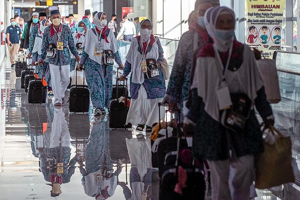 BERANGKAT: Sebahagian daripada kumpulan pertama jemaah haji Indonesia yang berlepas dari Lapangan Terbang Antarabangsa Juanda di Surabaya pada 4 Jun. Semua jemaah akan diberi beg berisi peralatan kesihatan seperti pelitup dan sanitasi tangan. - Foto 