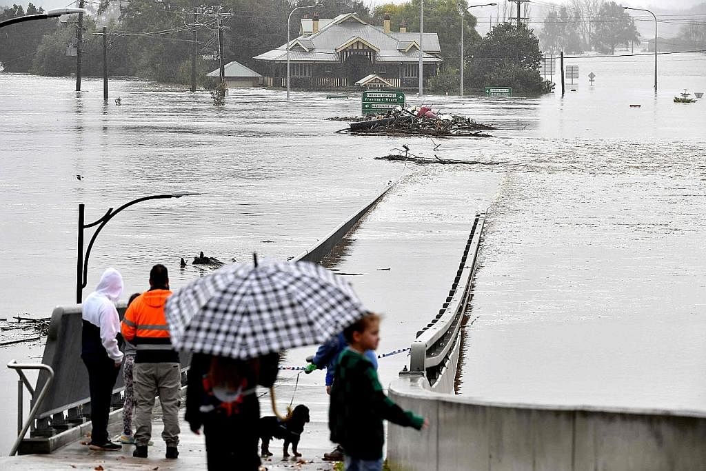TENGGELAM: Jambatan ini 'hilang' ditenggelami air. Selain jambatan, rumah dan ladang juga ditenggelami air ekoran hujan lebat di New South Wales. - Foto AFP