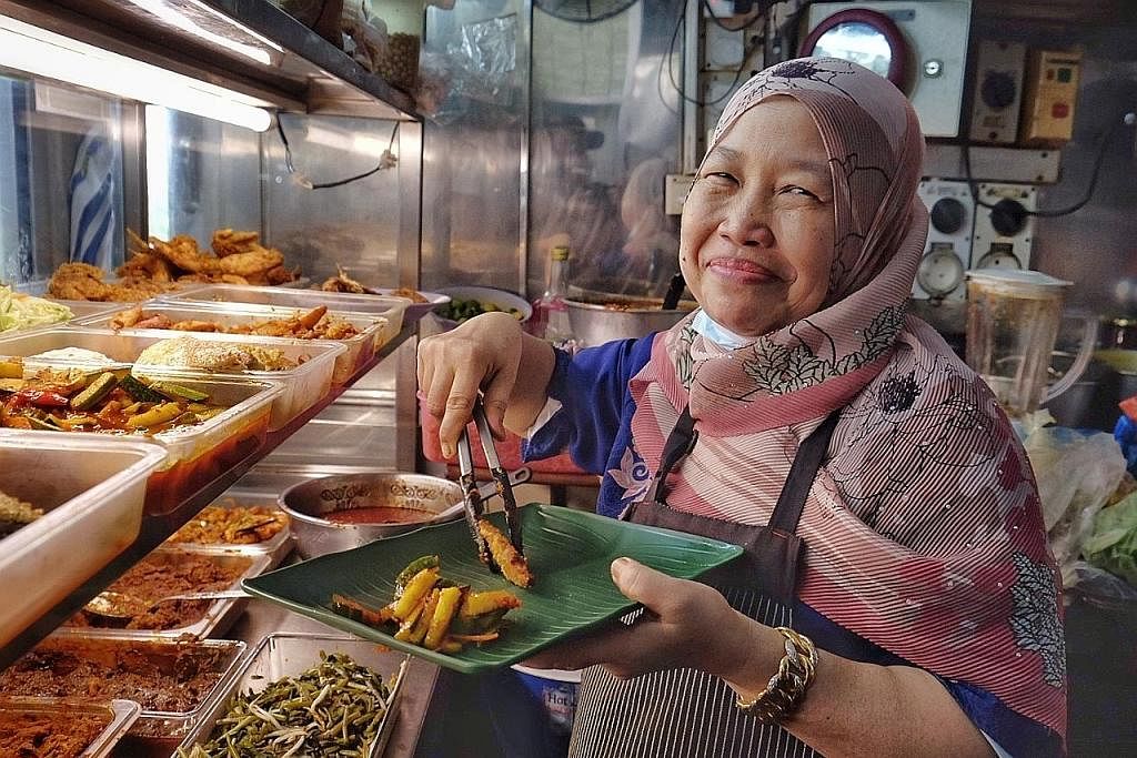 MAKANAN PENJAJA MASIH DIMINATI RAMAI: Cik Siti Aisyah yakin bahawa makanan dan budaya penjaja tidak akan luput ditelan zaman. - Foto BH oleh KHALID BABA