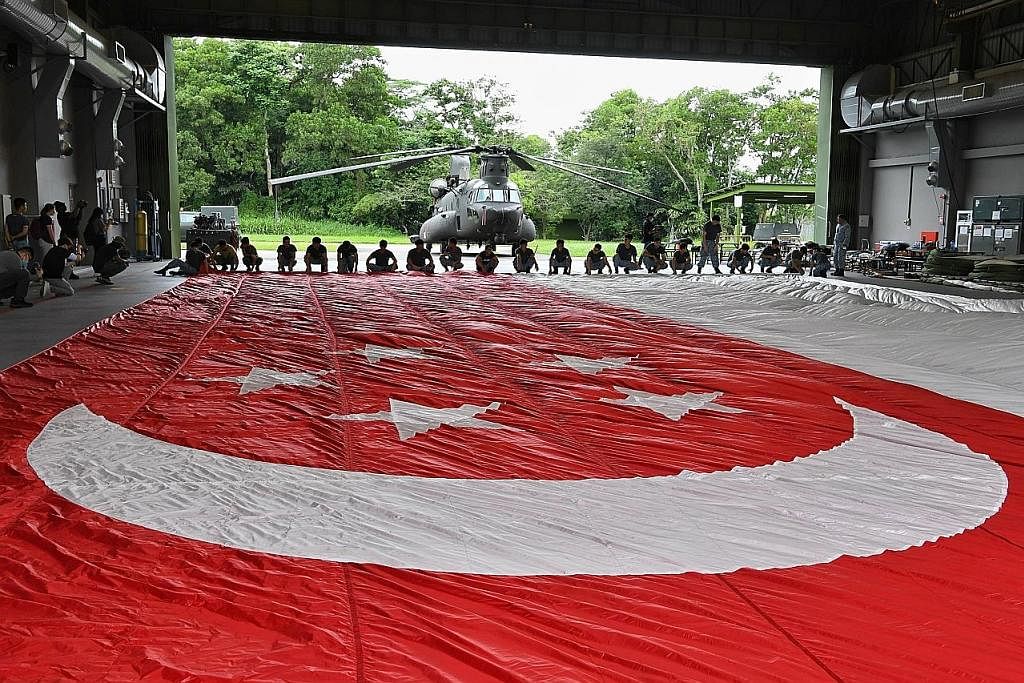 AHLI PASUKAN BENDERA: (Dari kiri) ME2 Lin Cai Yu, ME3 Law Wooi Pin dan ME1 (NS) Tang Wei Chi. Ketiga-tiga merupakan ahli pasukan bendera untuk NDP tahun ini. - Foto-foto ST BENDERA RAKSASA: Bendera Singapura yang akan dikibar dari helikopter pada Har