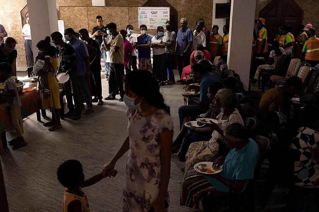 KRISIS EKONOMI: Sukarelawan mengagihkan makanan percuma dari dapur masyarakat di dalam gereja untuk sebahagian penduduk. - Foto REUTERS