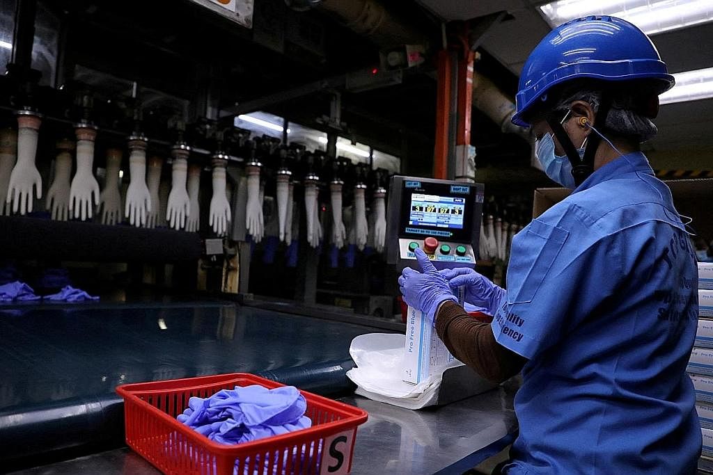 PERMINTAAN BERKURANG: Seorang pekerja di kilang membuat sarung tangan, Top Glove di Shah Alam, Malaysia. - Foto REUTERS