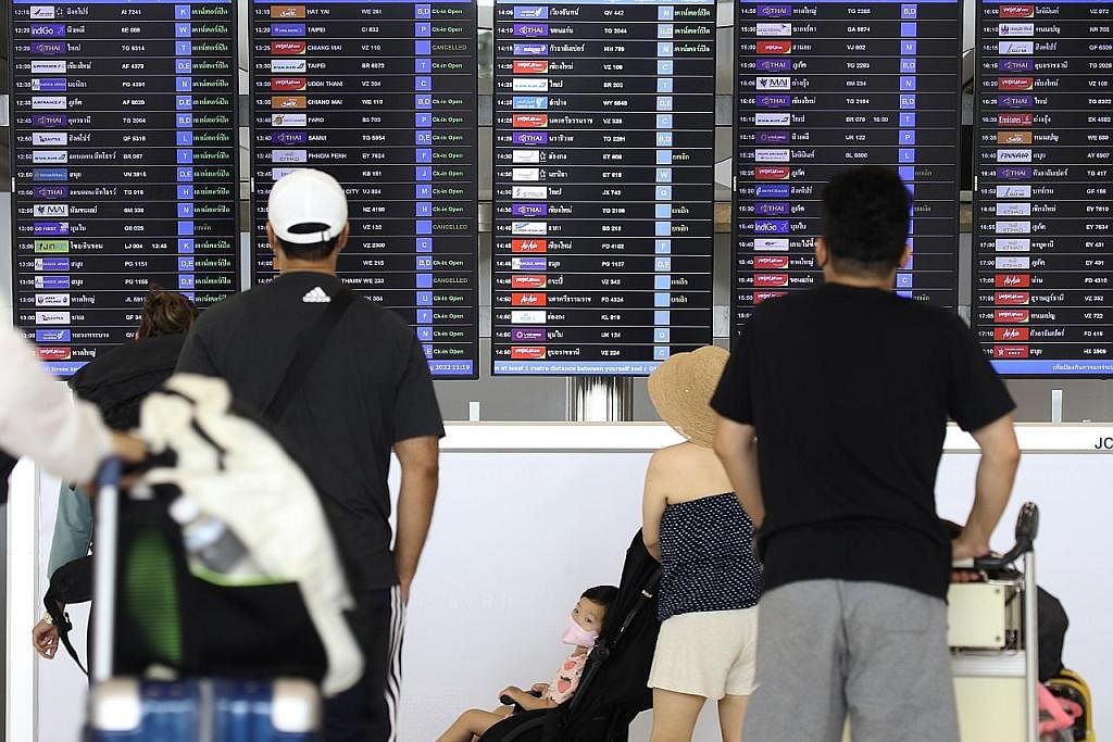 ELAKKAN RUANG UDARA: Penumpang melihat papan maklumat penerbangan di Lapangan Terbang Antarabangsa Suvarnabhumi di wilayah Samut Prakan, Thailand semalam. Thailand telah memberitahu tiga syarikat penerbangan negara itu supaya mengelakkan ruang udara 