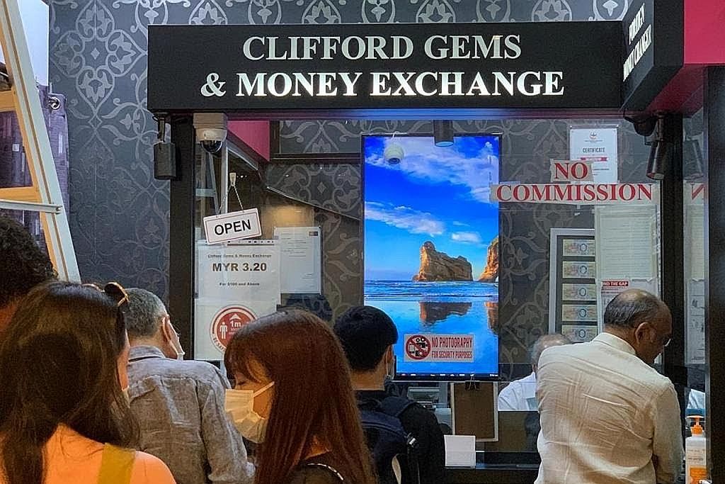 BERATUR PANJANG: Beberapa pelanggan kelihatan beratur panjang di Clifford Gems & Money Exchange di Raffles City bagi menukar mata wang asing Khamis lalu. - Foto CLIFFORD GEMS AND MONEY EXCHANGE