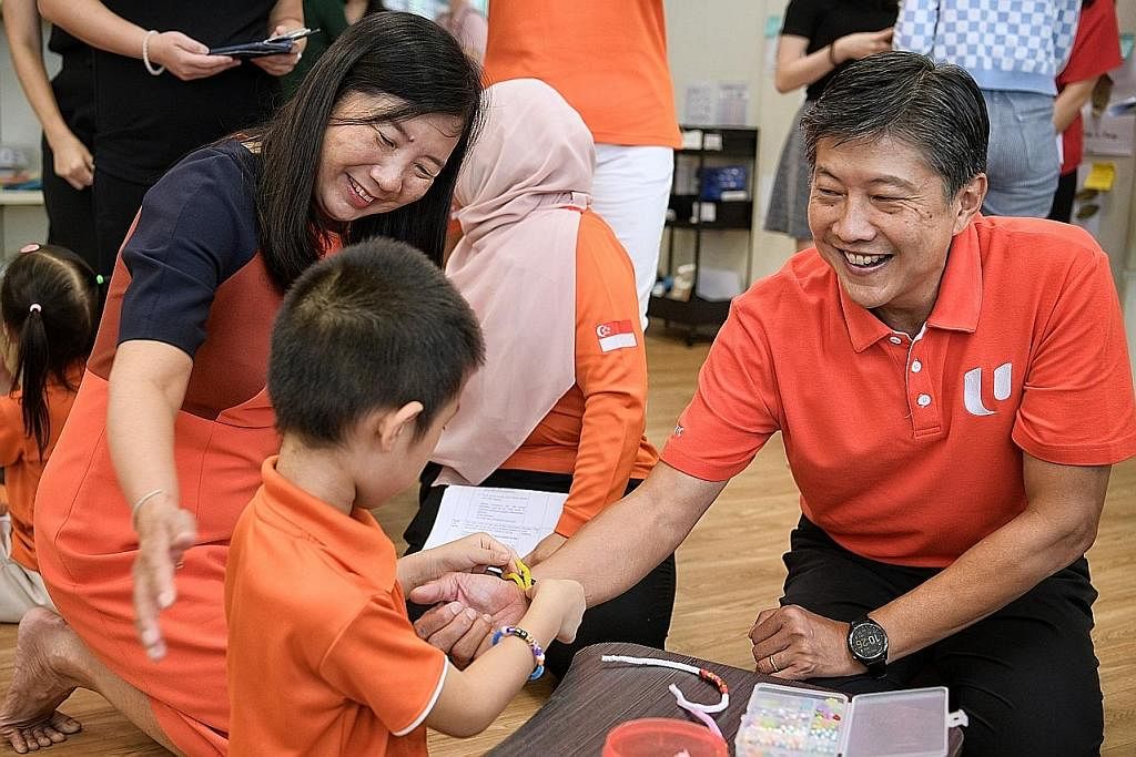 INTERAKSI BERSAMA: Seorang kanak-kanak memakaikan gelang pada tangan Encik Ng Chee Meng semasa lawatan beliau ke prasekolah My First Skool di Yung An Road semalam. - Foto BH oleh NG SOR LUAN