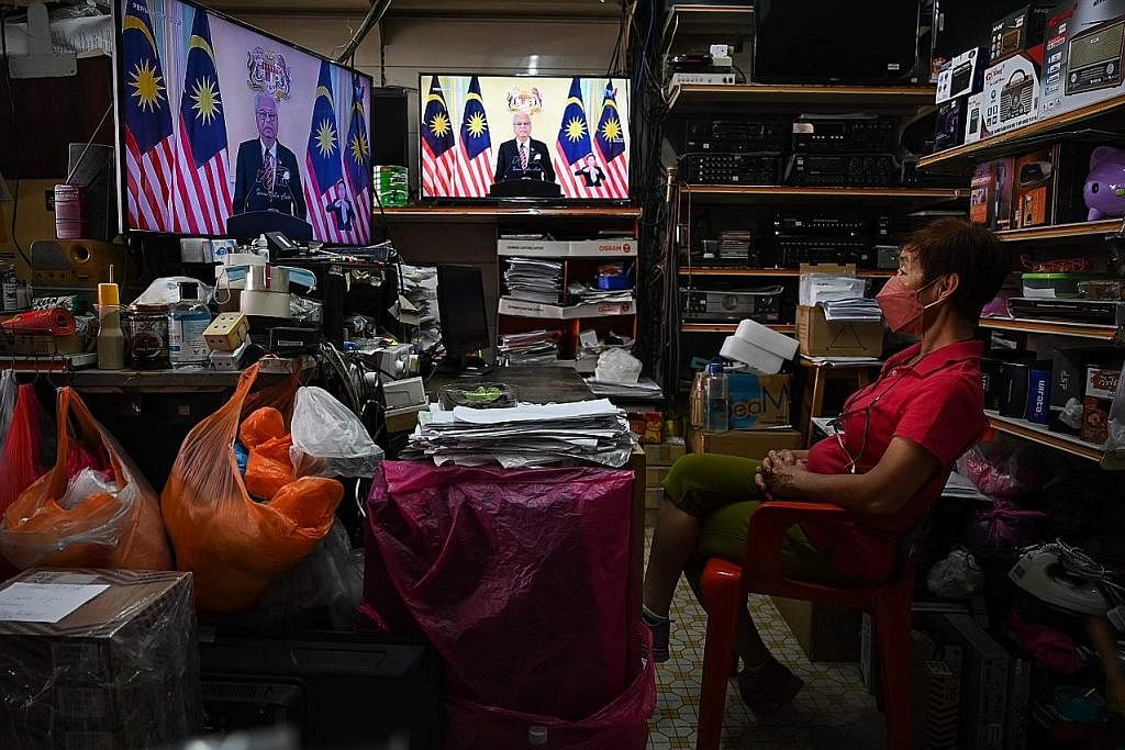 BUBAR: Seorang wanita menonton televisyen apabila Datuk Seri Ismail Sabri Yaakob mengumumkan pembubaran Parlimen bagi memberi laluan kepada Pilihan Raya Umum Ke-15. - Foto AFP