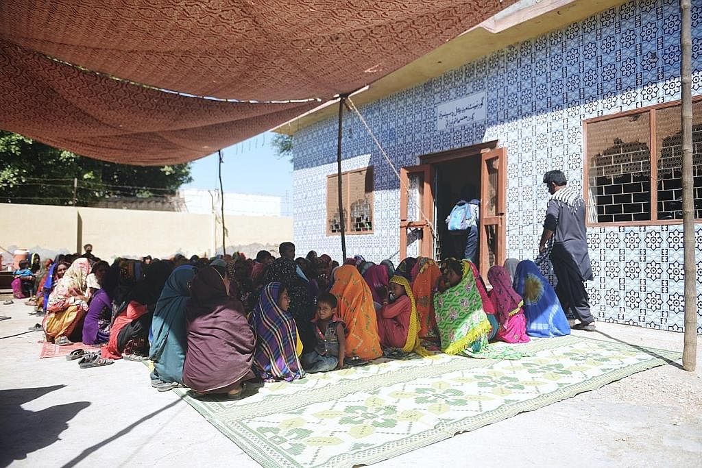 BERATUR PANJANG: Ratusan wanita duduk di luar sebuah bangunan pemberian ubat kampung yang diguna sebagai pusat rawatan percuma bagi ibu baru dan akan bersalin di kampung Mohammad Hashim Noodan, daerah Tando Allahyar, wilayah Sindh, Pakistan. KORBAN D