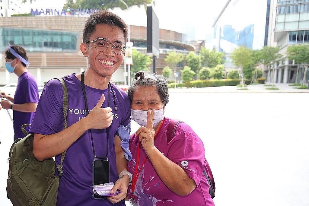 BERI SOKONGAN: Sukarelawan Pasukan Belia Singapura (YCS), Encik Syazwan Zainal Shah (kiri), berinteraksi dengan klien rakan kongsi komuniti YCS, Thye Hua Kwan Moral Charities, di The Purple Parade, Sabtu lalu.