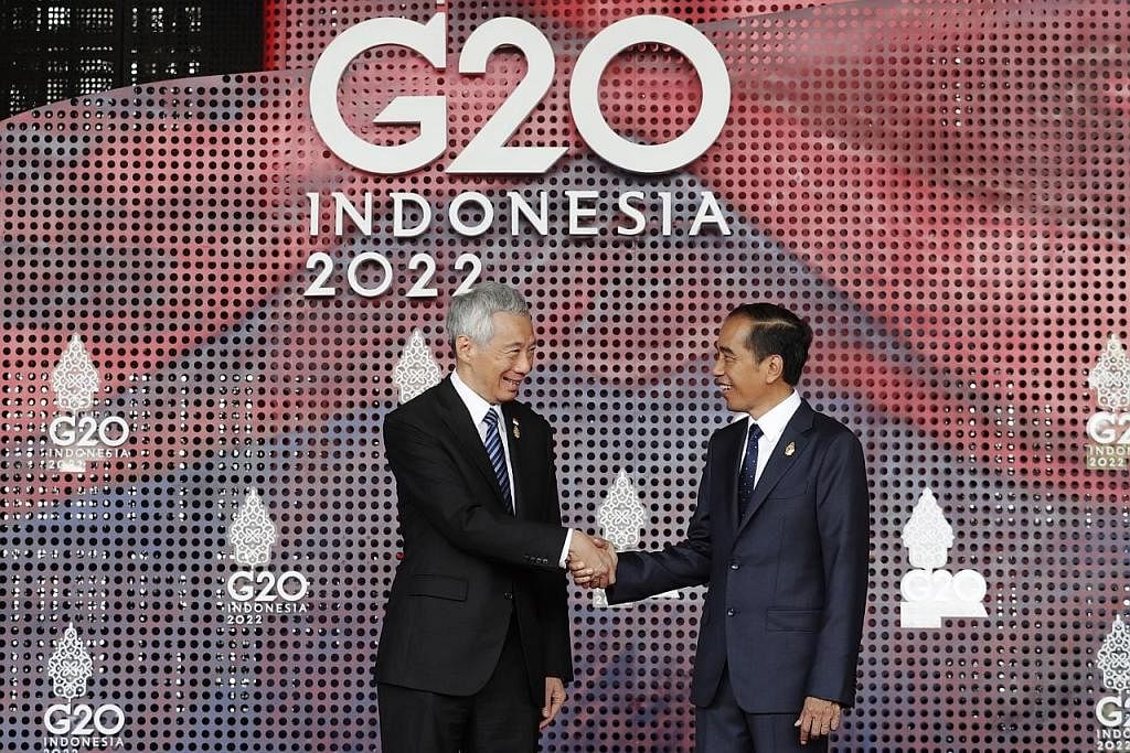 DISAMBUT MESRA: Encik Lee (kiri) disambut oleh Presiden Jokowi pagi semalam sebelum Sidang Puncak G20 dibuka secara rasmi. - Foto EPA-EFE