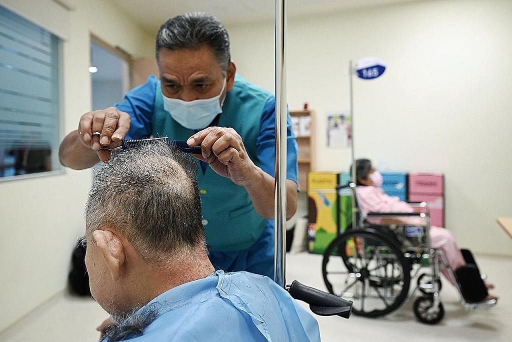 GUNTING RAMBUT: Sebulan sekali, Encik Taha meluangkan masa di Hospital Masyarakat Jurong untuk menggunting rambut pesakit yang tinggal di sana untuk jangka masa panjang. (Gambar sisipan) menunjukkan Encik Taha sedang menggunting rambut seorang pesaki