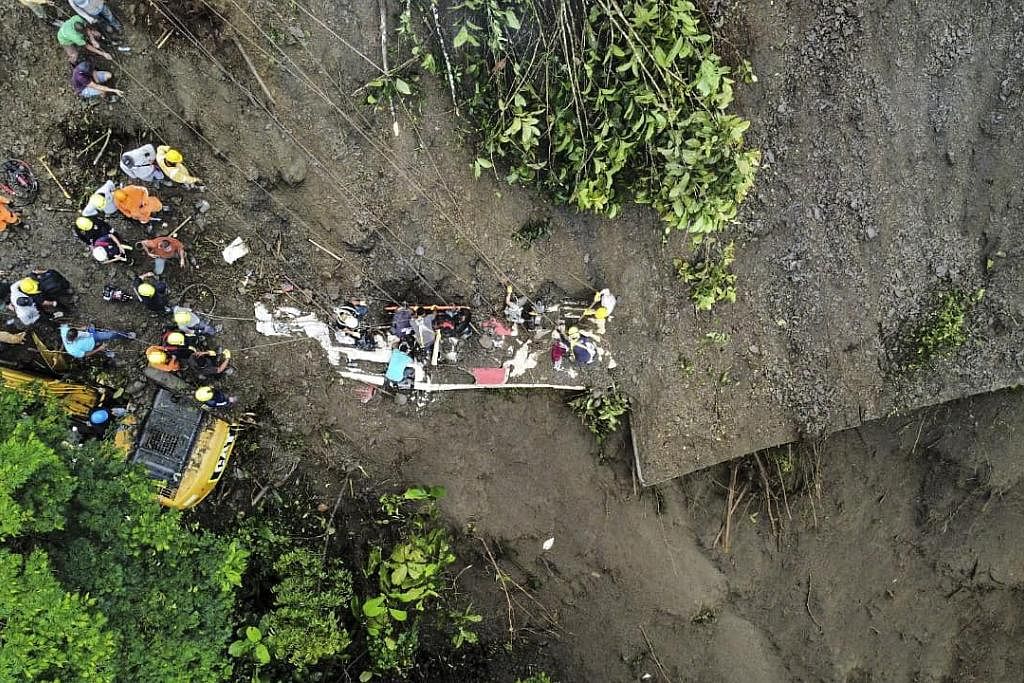 USAHA MENYELAMAT: Gambar dari udara yang dikeluarkan pejabat pertahanan awam Colombia menunjukkan kejadian tanah runtuh yang menimbus sebuah bas di kawasan Pueblo Rico. - Foto AFP