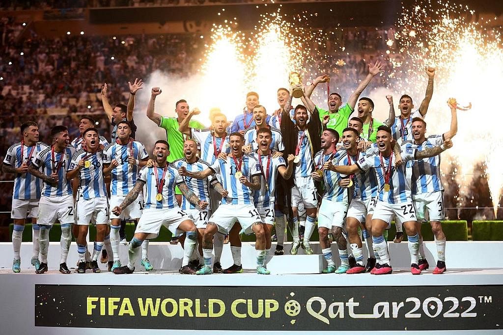 RAI KEJAYAAN SEBAGAI JUARA DUNIA: Bintang Argentina, Lionel Messi (baris depan, lima dari kanan, berpakaian tradisional Arab bernama 'bisht'), menjulang Piala Dunia bersama rakan-rakannya selepas mereka menewaskan Perancis menerusi sepakan penalti da