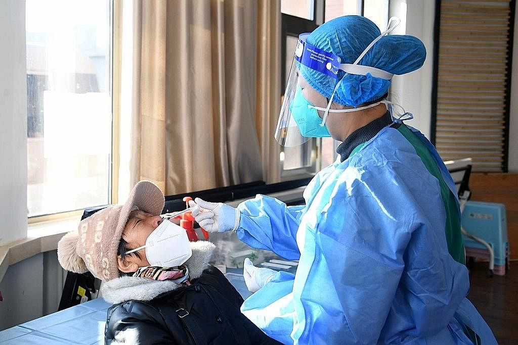 SUNTIKAN PENGGALAK: Seorang petugas perubatan memberi suntikan penggalak kedua bagi vaksin Covid-19 ke atas seorang pesakit di Daerah Haidian, Beijing, ibu kota China, pada 17 Disember lalu. - Foto EPA-EFE