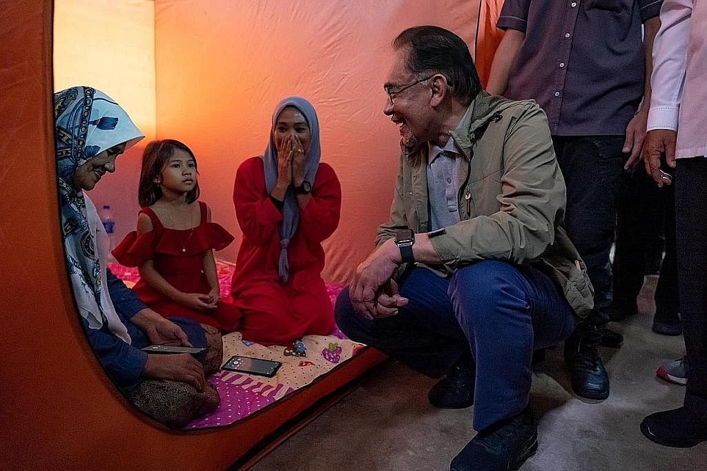 TINJAU KEADAAN: Datuk Seri Anwar Ibrahim melawat mangsa banjir di sebuah pusat pemindahan sementara di Pasir Mas, Kelantan kelmarin. - Foto FACEBOOK ANWAR IBRAHIM MANGSA BANJIR: Keputusan untuk memperuntukkan $15.21 juta kepada kedua-dua negeri itu d
