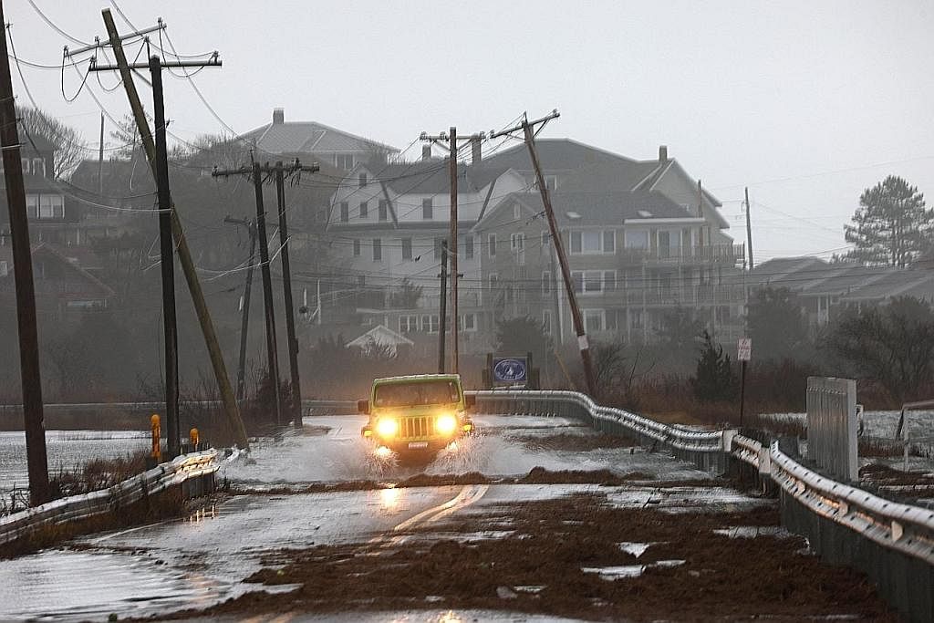 KESEJUKAN ARTIK YANG BAHAYA: Seorang pemandu melalui jalan yang telah dibanjiri ketika air pasang semasa ribut musim sejuk di Gloucester, Massachusetts, Amerika Syarikat kelmarin. - Foto REUTERS
