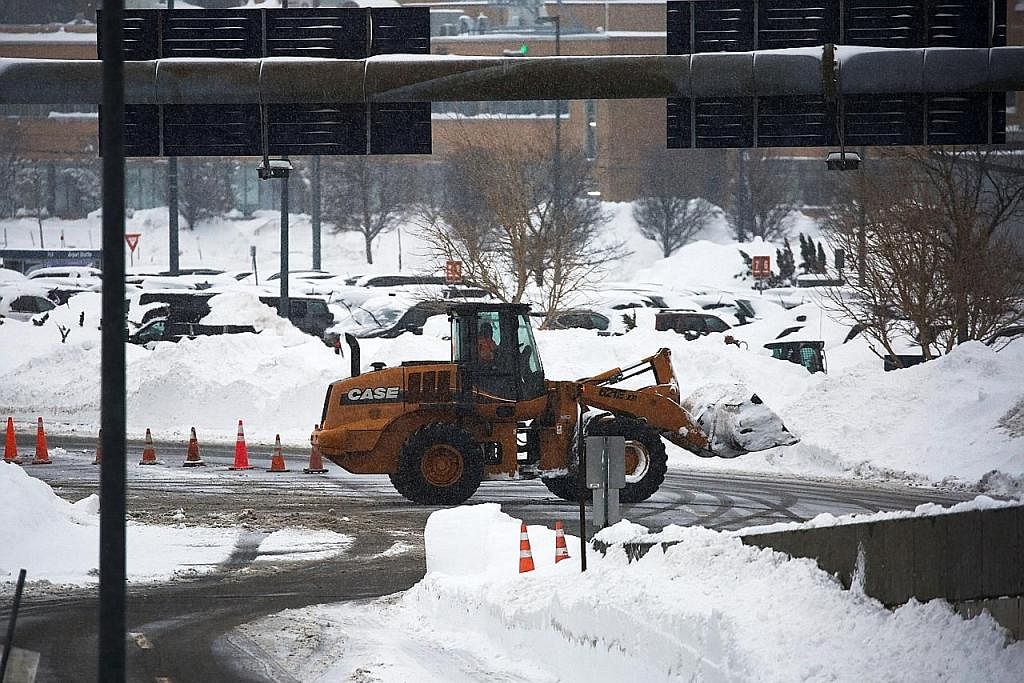 TIMBUNAN SALJI: Seorang petugas memandu jentolak bagi membersihkan jalan yang tidak boleh dilalui kenderaan di Lapangan Terbang Antarabangsa Niagara, Buffalo, New York, kelmarin akibat ribut salji terburuk yang melanda negeri itu. - Foto REUTERS