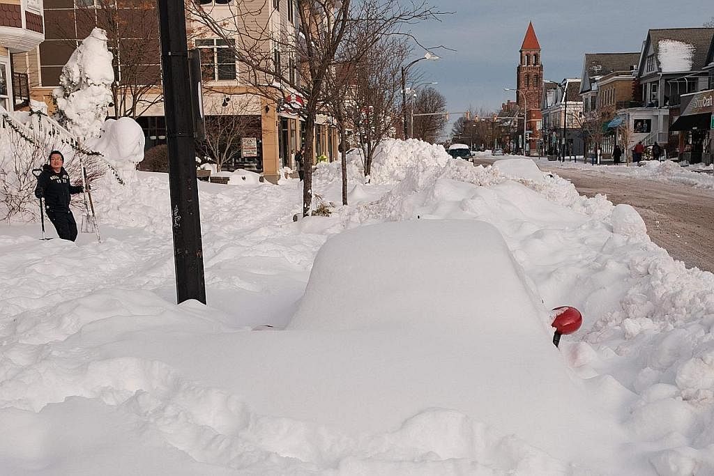 DITIMBUS SALJI: Sebuah kereta tertimbus dalam salji di Buffalo. Kakitangan kecemasan terpaksa memeriksa dari satu ke satu kereta mencari pemandu, sama ada hidup atau mati. - Foto AFP