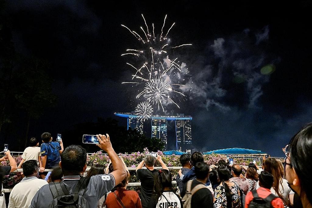 ACARA ISTIMEWA: Orang ramai berkumpul di Marina Bay untuk menikmati pertunjukan bunga api yang diadakan sempena sambutan Tahun Baru. - Foto REUTERS SESAK: Jambatan dan ruang umum di sekitar Marina Bay dibanjiri warga yang berhimpun untuk menyambut ke